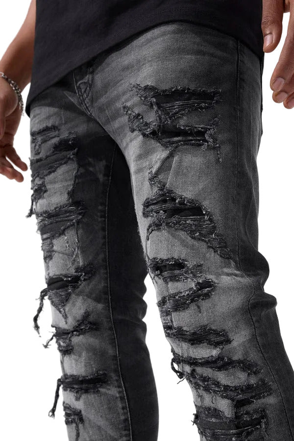 Slim taper fit denim jeans with rip-and-repair detailing and vintage-inspired distressing.