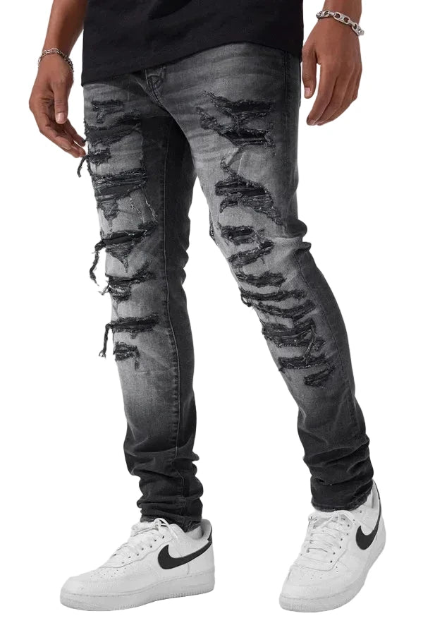 Slim taper fit denim jeans with rip-and-repair detailing and vintage-inspired distressing.