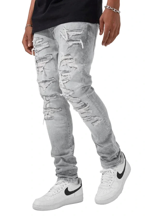 Slim taper fit denim jeans with rip-and-repair detailing and vintage-inspired distressing.