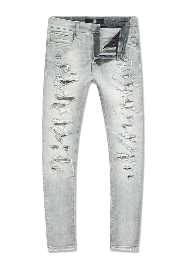 Slim taper fit denim jeans with rip-and-repair detailing and vintage-inspired distressing.