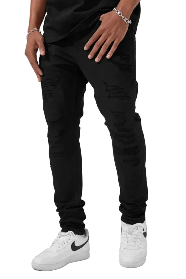 Alkaline Denim slim taper fit jeans in jet black with rip-and-repair detailing and vintage-inspired distressing.