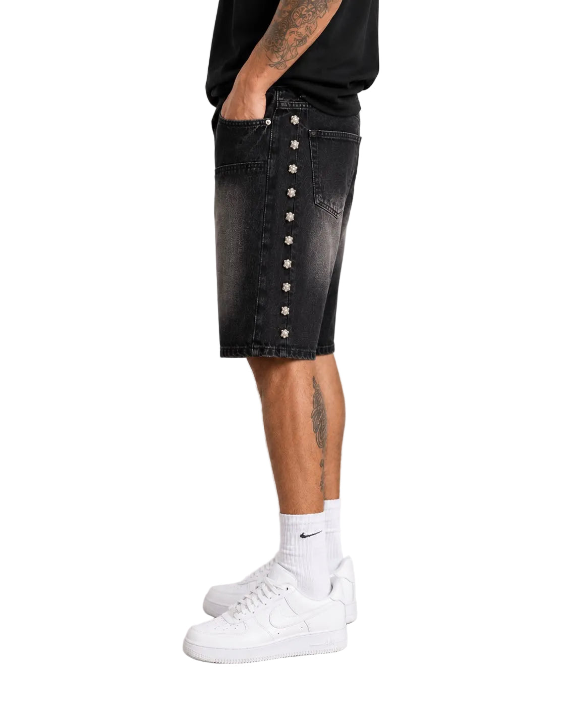 Side view of male model wearing black Kindred denim shorts featuring metallic skull stud detailing