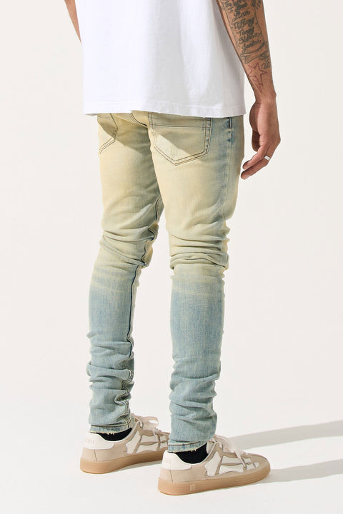 SERENEDE® LIMESTONE Jeans in vintage earth yellow with fitted construction, overdyed finish, fading, and embroidered [S]® logo.