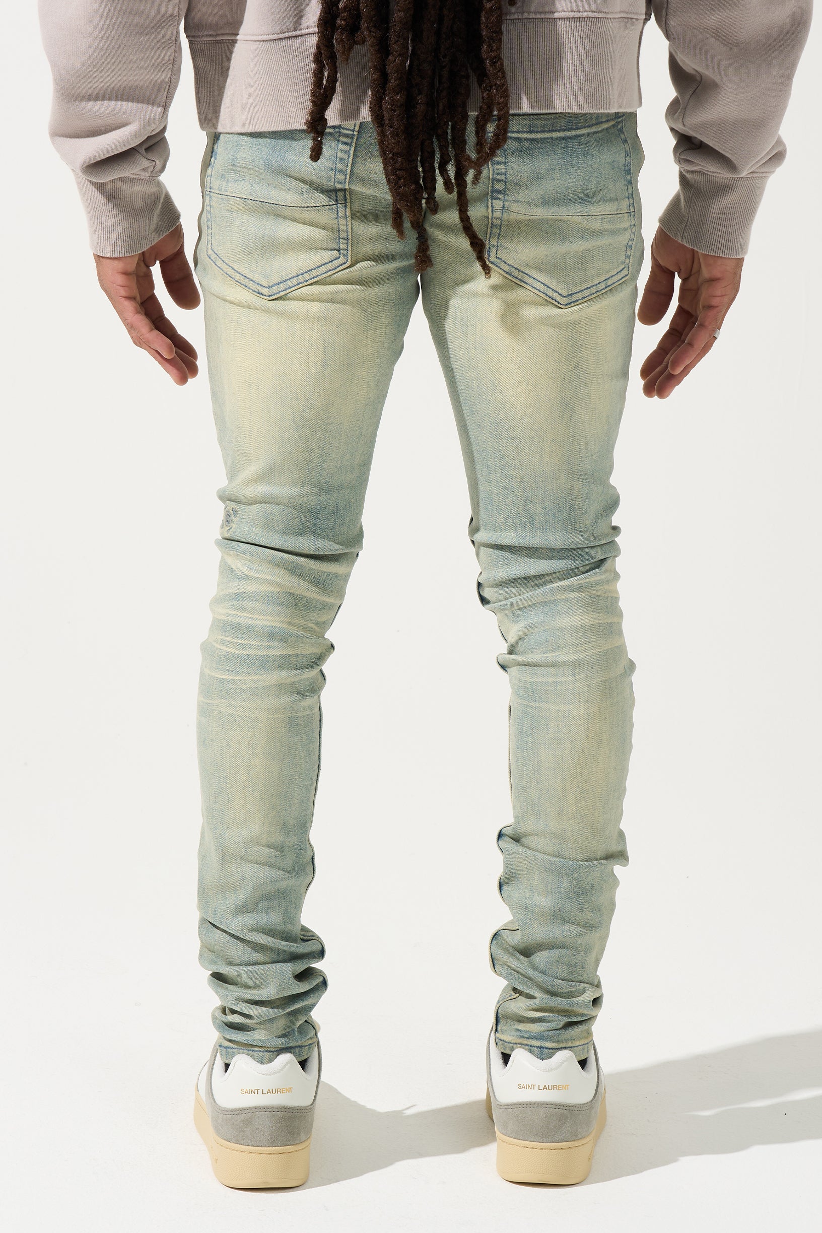 SERENEDE® Nomad Jeans in light vintage earth wash with resin wax coating, fitted construction, subtle fading, and branded hardware.