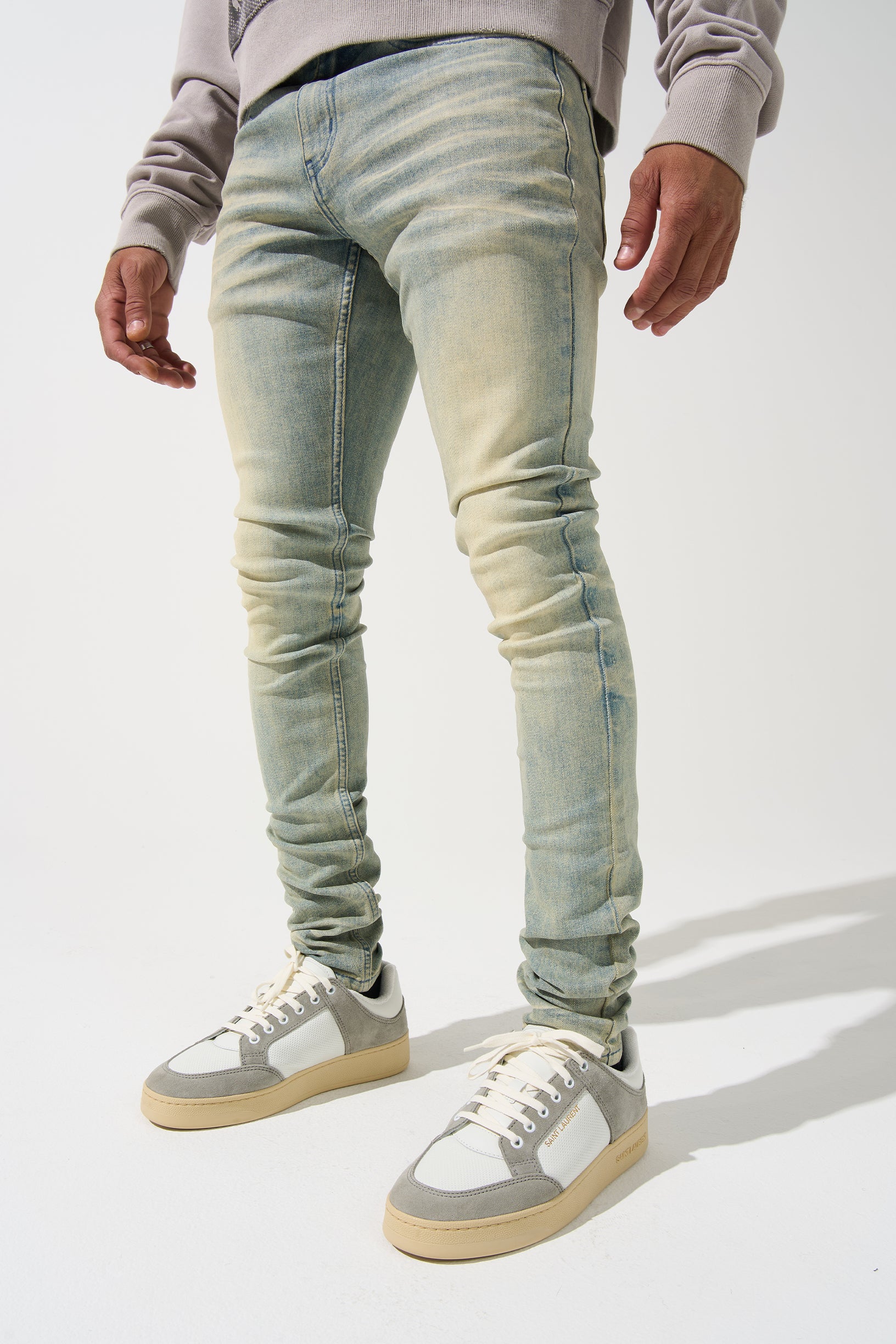 SERENEDE® Nomad Jeans in light vintage earth wash with resin wax coating, fitted construction, subtle fading, and branded hardware.