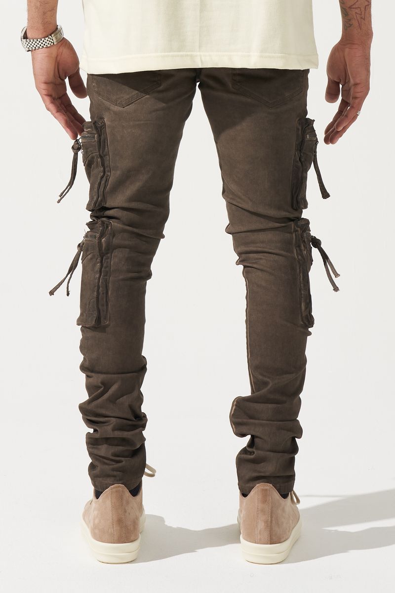 SERENEDE® OUD cargo jeans in brown overdye with fitted silhouette, cargo pockets, and branded leather waistband patch.