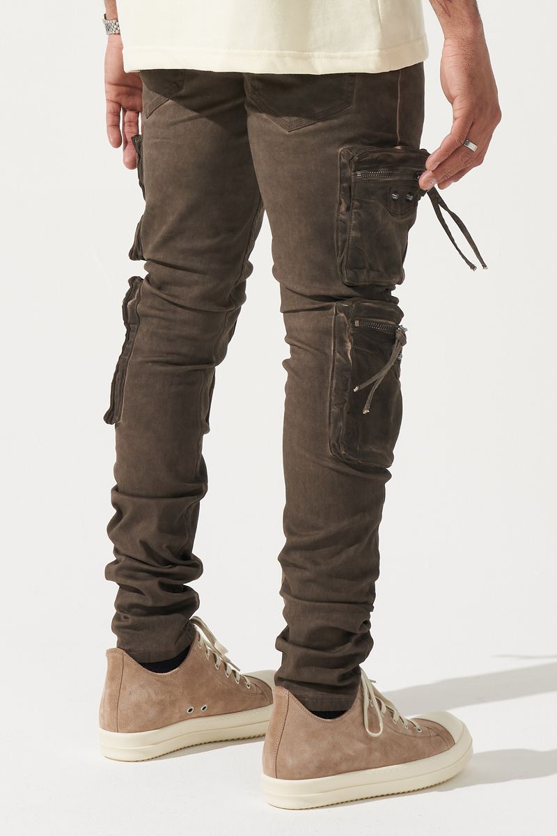 SERENEDE® OUD cargo jeans in brown overdye with fitted silhouette, cargo pockets, and branded leather waistband patch.