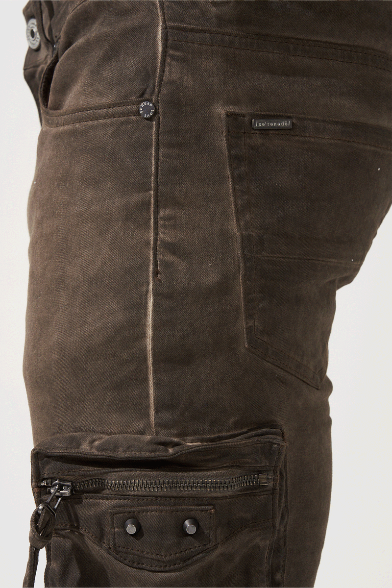 SERENEDE® OUD cargo jeans in brown overdye with fitted silhouette, cargo pockets, and branded leather waistband patch.