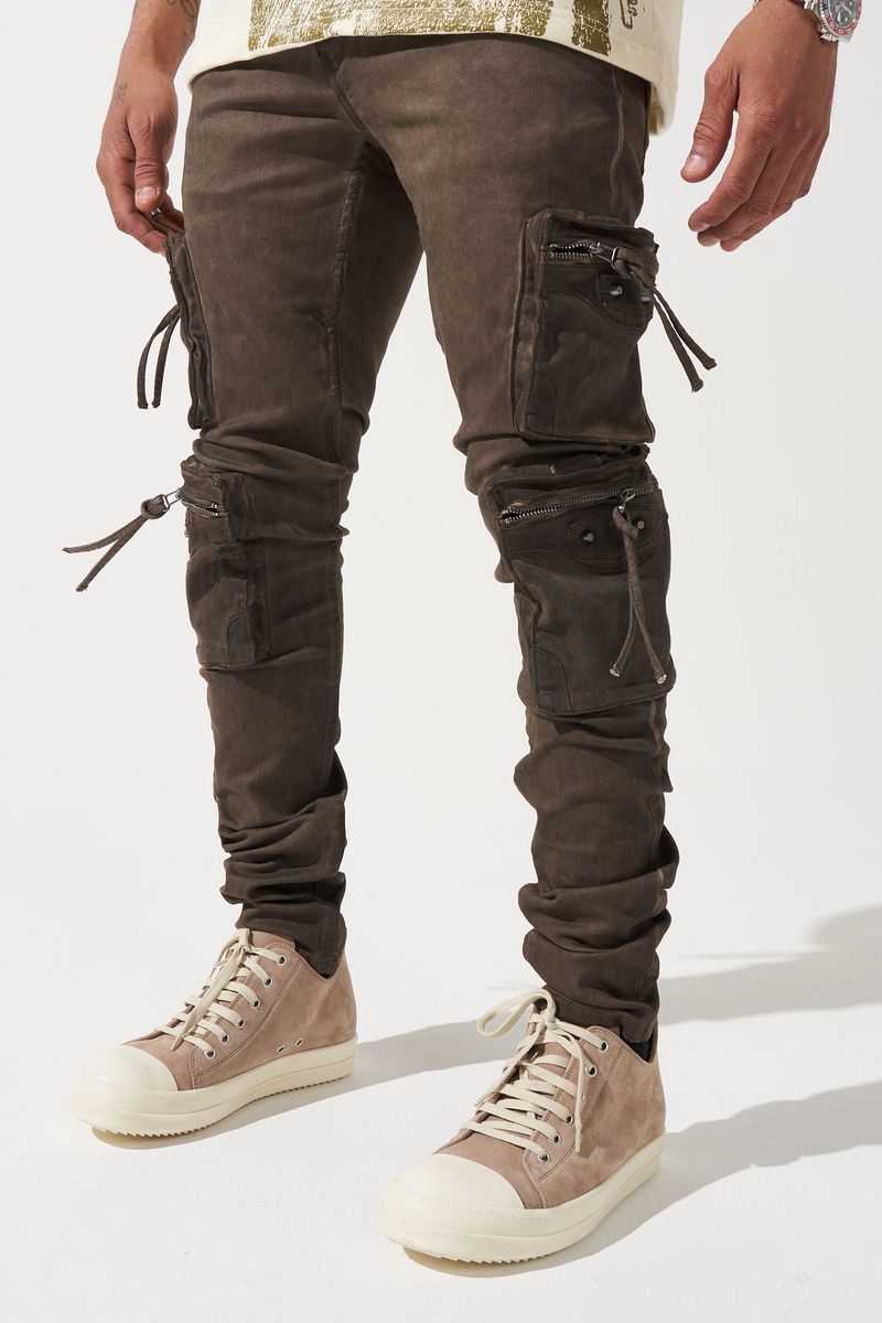 SERENEDE® OUD cargo jeans in brown overdye with fitted silhouette, cargo pockets, and branded leather waistband patch.