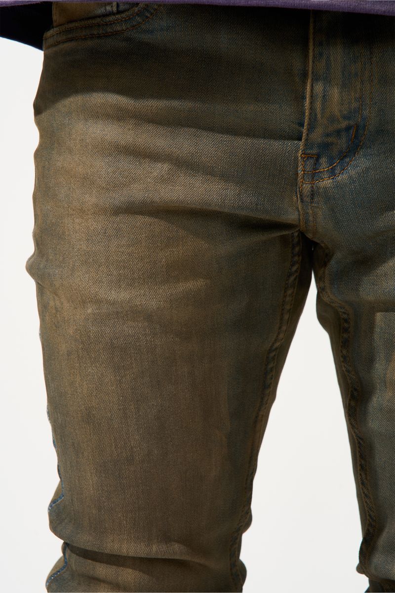 SERENEDE® OUD stacked jeans in dark denim with brown overdye, knee distressing, and signature stacked silhouette.