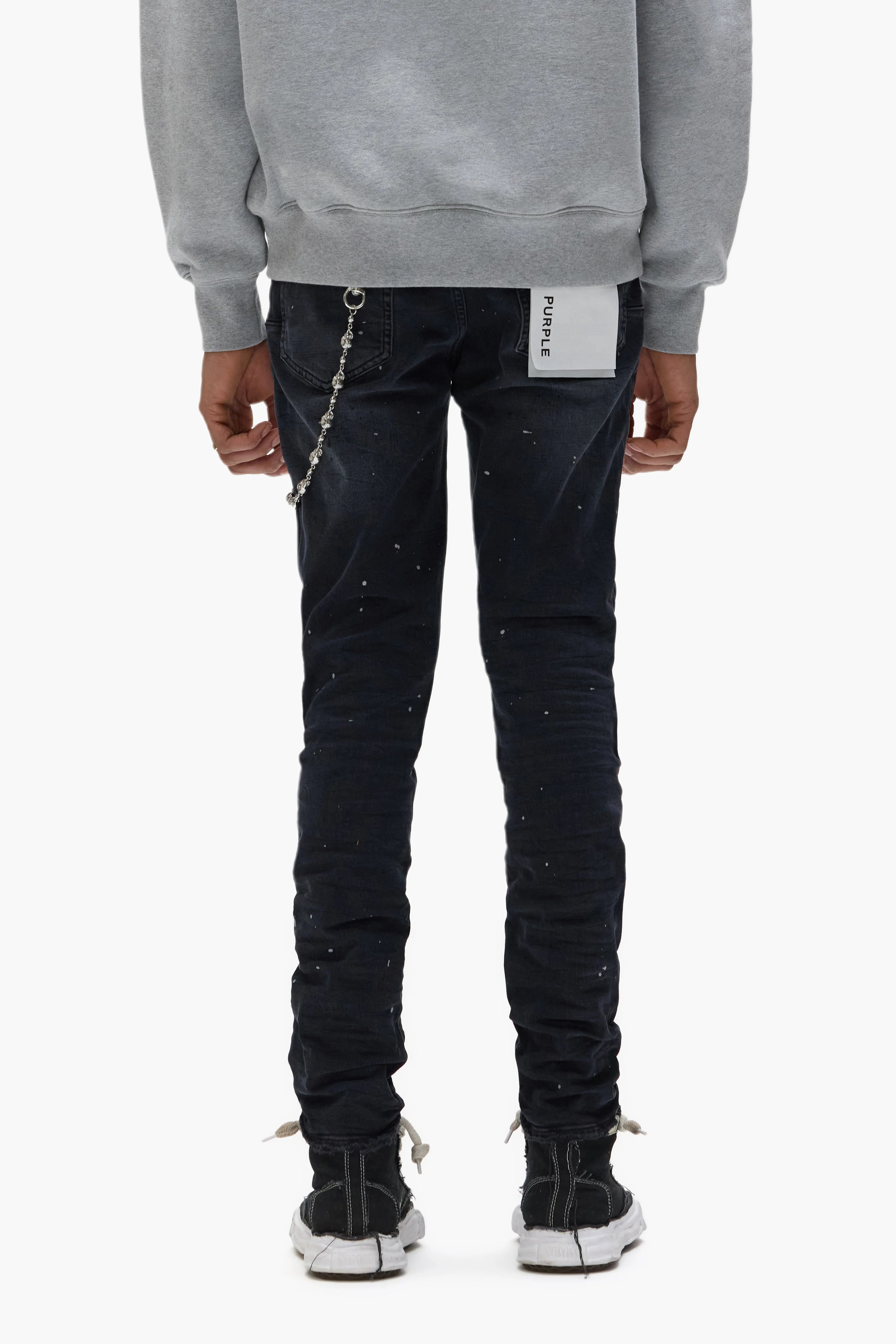 Purple Brand Core White Label black skinny jeans with distressed knees, repaired and hand-finished detailing, reflective paint accents, and branded leather patch.