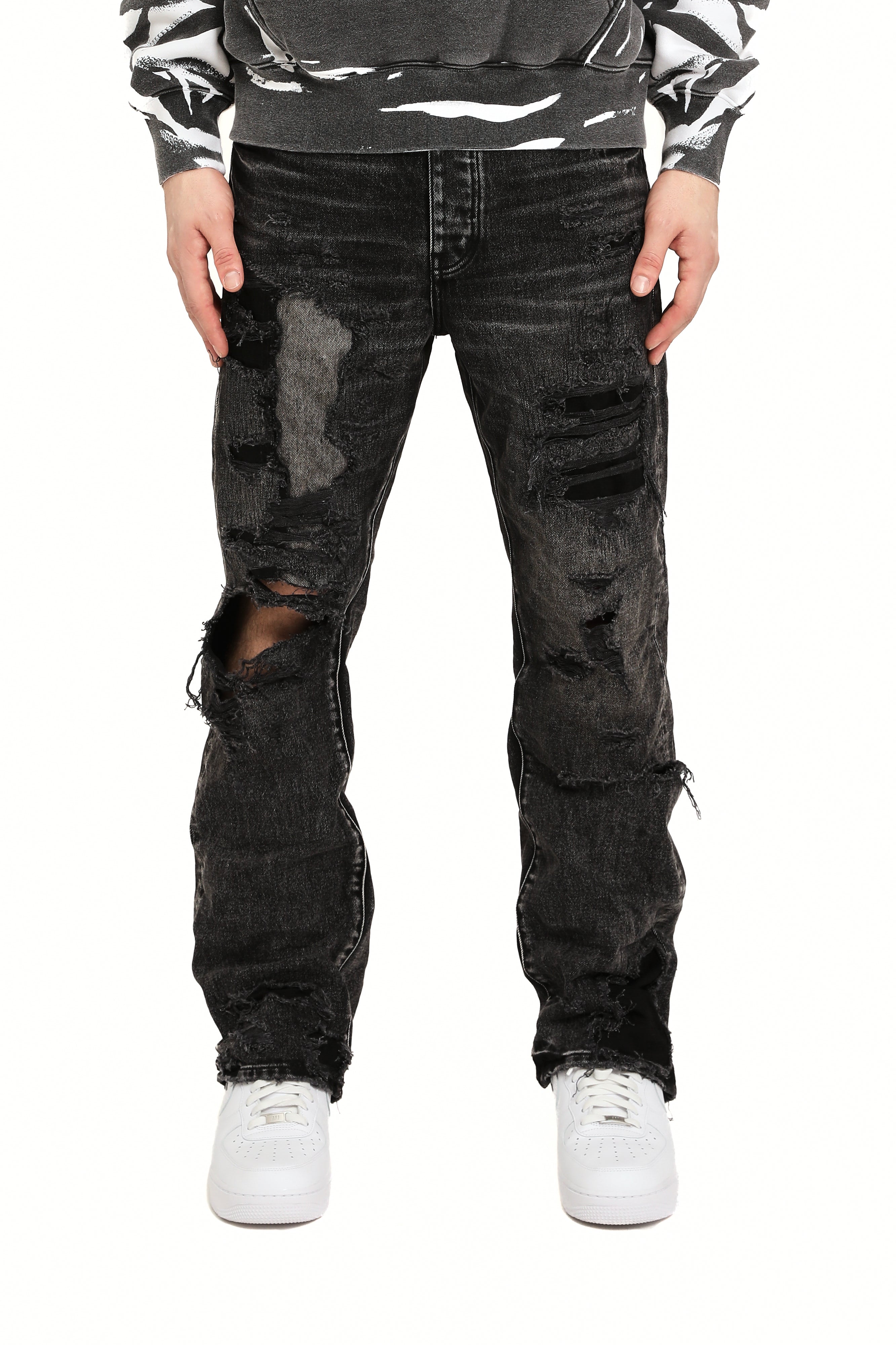 Purple Brand Repair Blowout Jeans in black denim featuring heavy distressing, repaired blowout details, and slim tapered fit.
