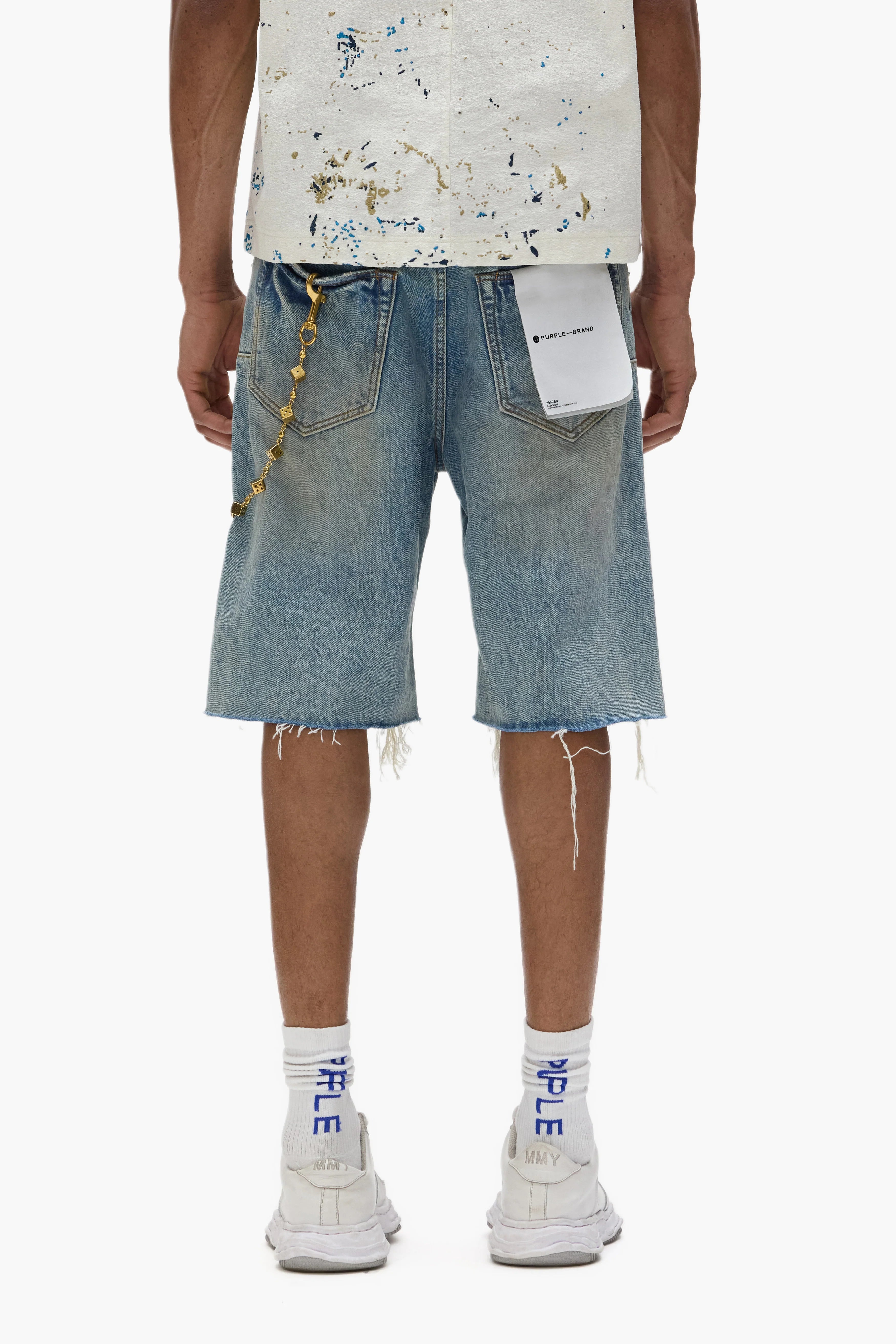 Purple Brand P059 Cutoff Denim Shorts in light indigo with rip-and-repair distressing, frayed hems, and signature leather patch detailing.