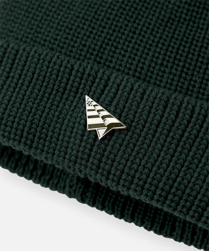 Paper Plane Wharfman beanie with rolled cuff, removable flag logo pin, and back flag label.