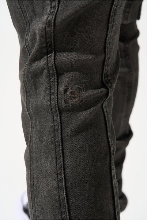 SERENEDE® RAIN smoke grey stacked jeans with carpenter panels, extended length, fitted silhouette, leather waistband patch, and branded hardware.