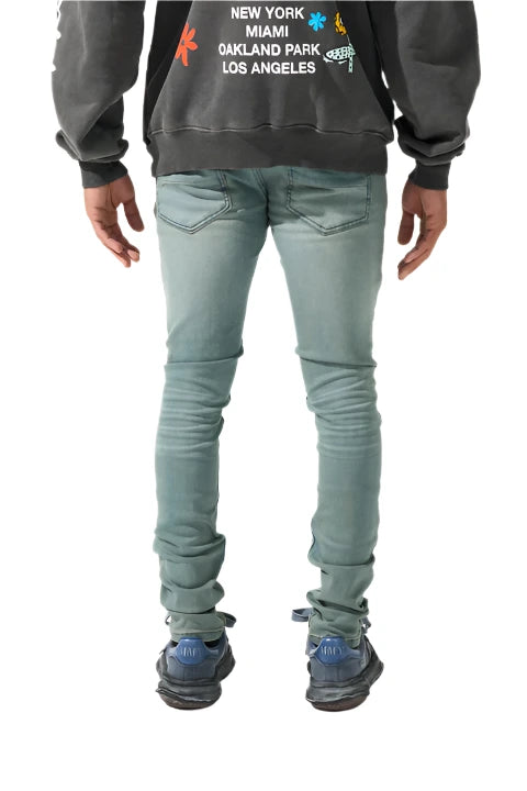 Slate blue skinny fit denim with fading, distressing, leather waistband patch, and SERENEDE® branded hardware.