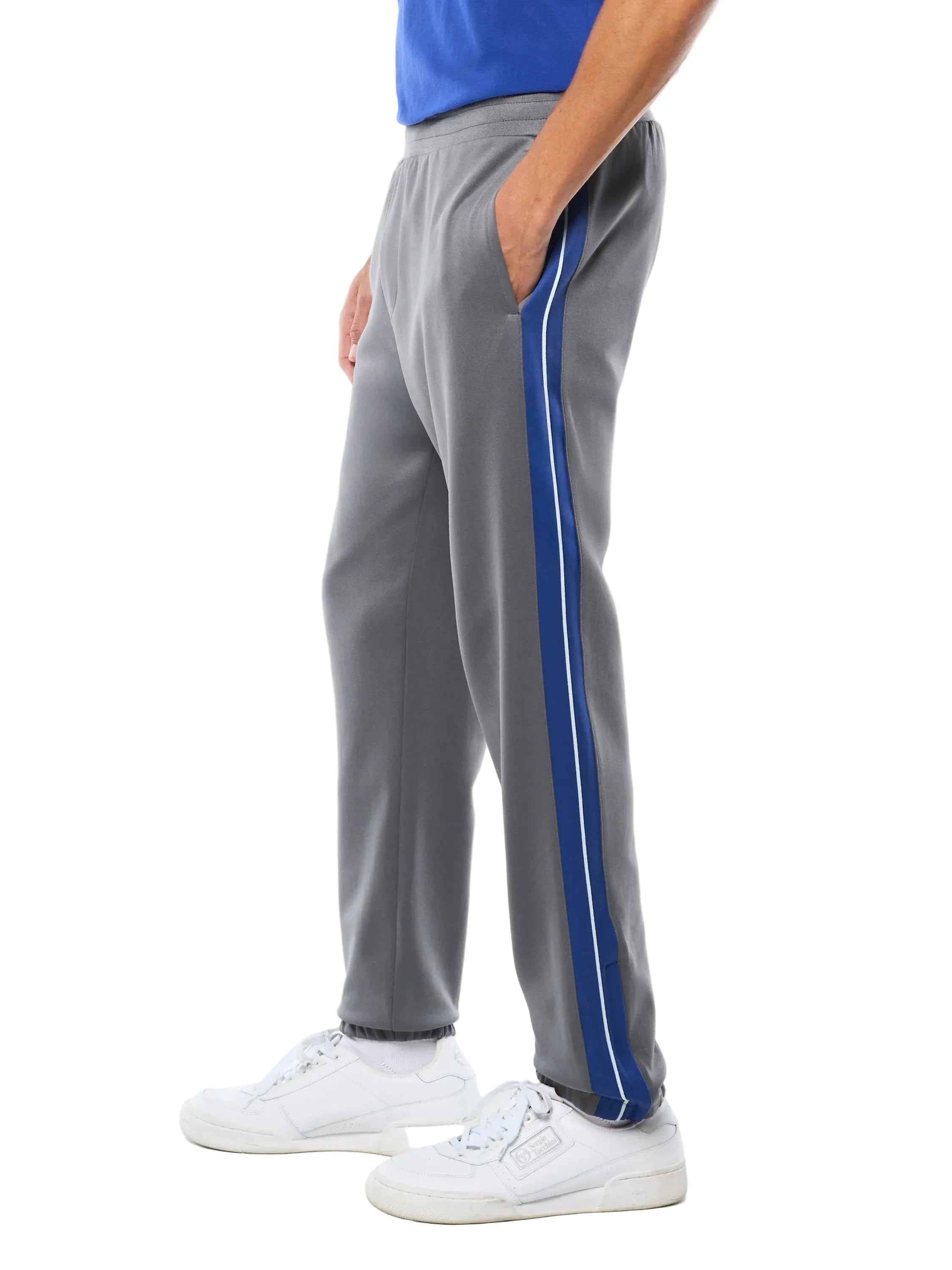 Premium track pants with elastic waistband, rear zippered welt pocket, embroidered Sergio Tacchini logo, contrast panels and piping down legs, and adjustable ankle zips
