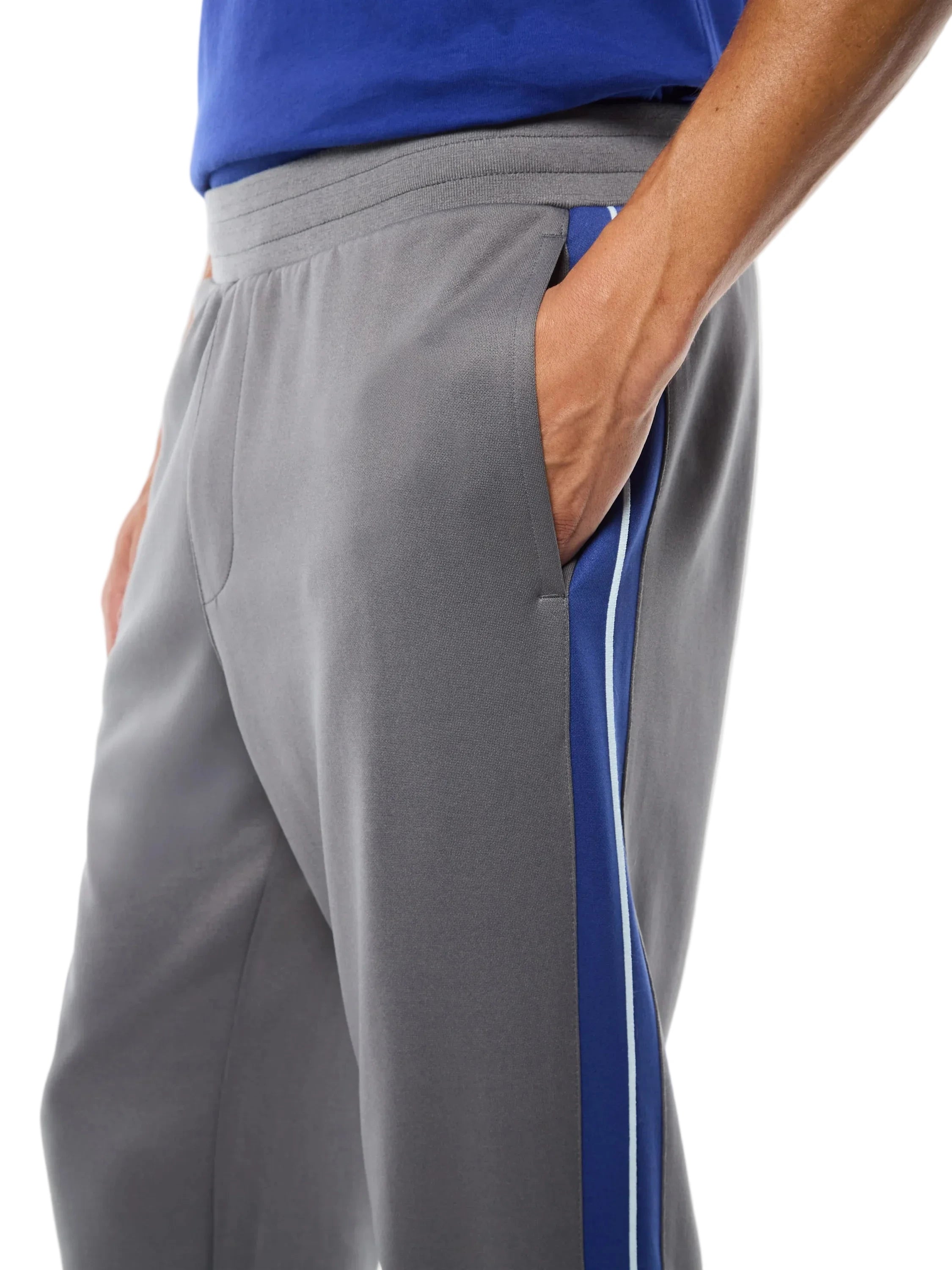 Premium track pants with elastic waistband, rear zippered welt pocket, embroidered Sergio Tacchini logo, contrast panels and piping down legs, and adjustable ankle zips