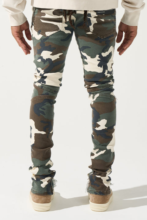 SERENEDE® SYNC Jeans in desert moss camo with fitted construction, biker panel details, embroidered [S]® logo, and holographic hangtag.