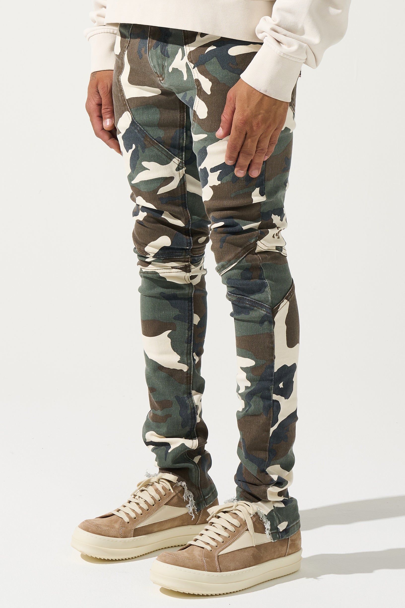 SERENEDE® SYNC Jeans in desert moss camo with fitted construction, biker panel details, embroidered [S]® logo, and holographic hangtag.