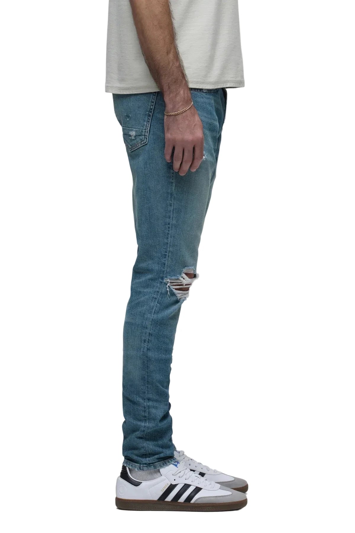 Zack Skinny Jeans in Canal medium indigo rigid denim with distressed knee details and a modern slim-fit silhouette.