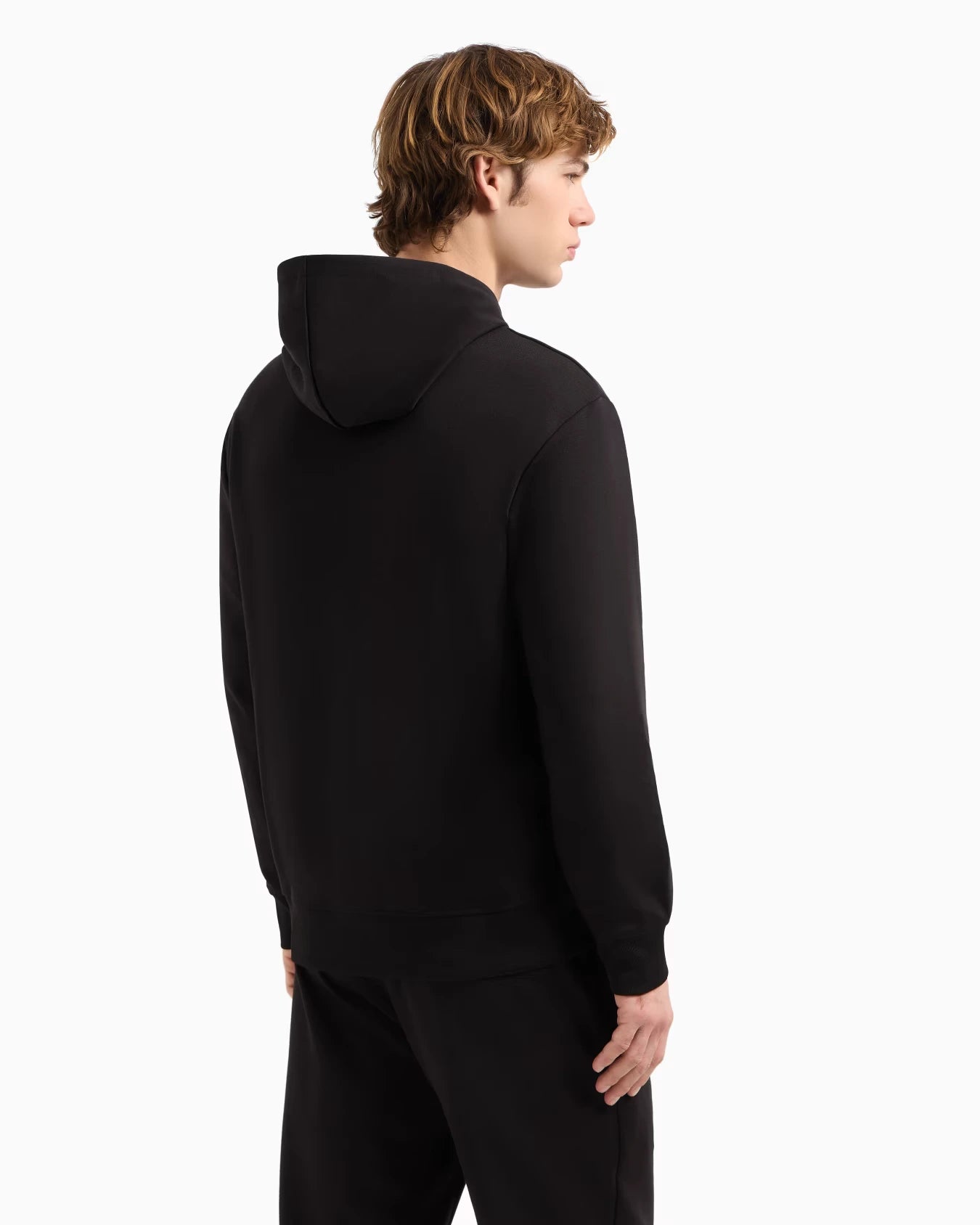 Person wearing a black hoodie from behind on a white background