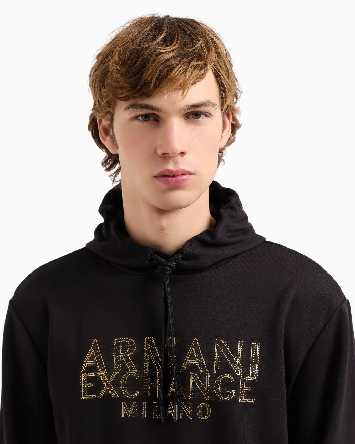 Person wearing a black Armani Exchange hoodie on a white background